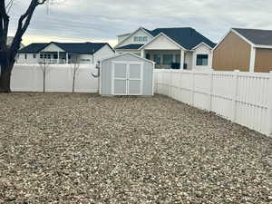 Fenced backyard with a storage shed