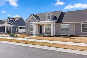 View of front of property with covered porch, a shingled roof, and board and batten siding