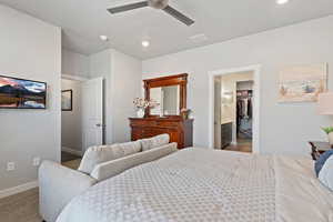 Bedroom with a walk in closet, ceiling fan, recessed lighting, and carpet flooring