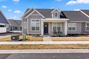 View of front of home with a shingled roof and covered porch