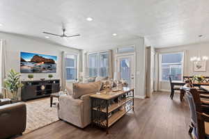 Living area featuring wood finished floors, a textured ceiling, a ceiling fan, suspended lighting, and healthy amount of natural light