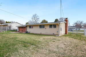 Rear view of house featuring a chimney, a patio, and a gate