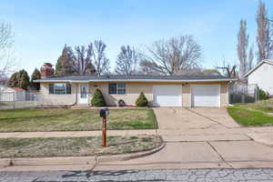 Ranch-style house with driveway, an attached garage, a gate, and a chimney