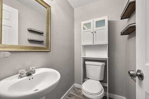 Half bathroom with a textured ceiling and dark wood-style flooring