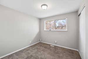 Unfurnished bedroom with dark colored carpet and a closet
