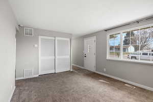 Carpeted foyer featuring baseboards