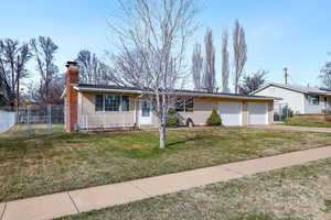 View of front of house with a gate, a chimney, a garage, and concrete driveway