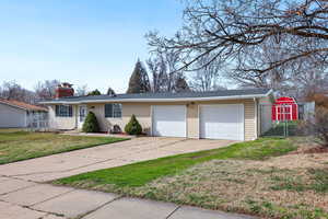 Single story home featuring concrete driveway, a chimney, an attached garage, and a gate
