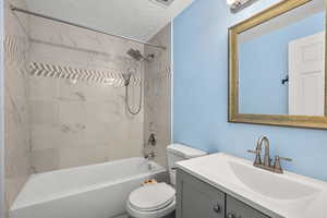 Full bathroom with vanity, a textured ceiling, and shower / bath combination