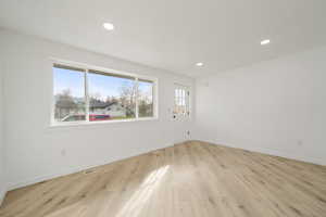 Empty room featuring light wood finished floors and recessed lighting