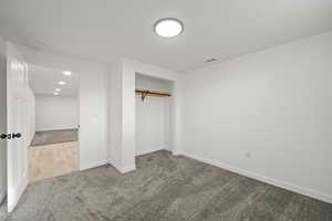 Unfurnished bedroom with a closet, carpet flooring, and recessed lighting