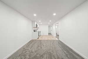 Unfurnished living room featuring recessed lighting and light carpet