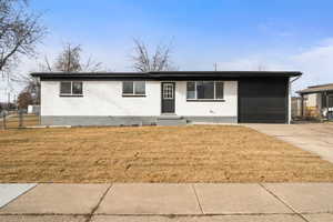 Single story home with brick siding, driveway, a front yard, and an attached garage