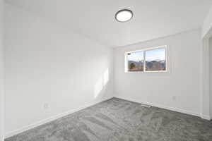 Carpeted empty room featuring baseboards