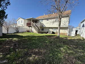 Back of property with a fenced backyard, a chimney, and a wooden deck