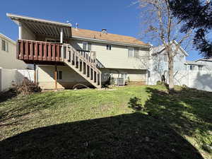 Rear view of property with stairs and a wooden deck