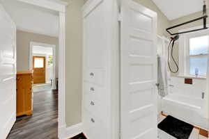 Bathroom with shower / bath combination and dark wood-type flooring