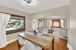 Dining space with light wood-style floors and arched walkways