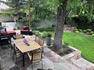 Fenced backyard featuring an outdoor stone fireplace, a patio area, and outdoor lounge area