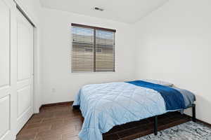 Bedroom with wood finish floors and a closet
