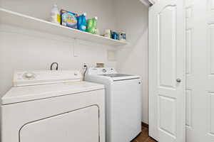 Laundry area featuring washing machine and clothes dryer and dark wood-style floors