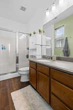 Full bathroom featuring vanity, a shower stall, and dark wood finished floors