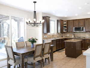Kitchen with rich wood finish cabinetry, a center island, stainless steel appliances, and granite countertops