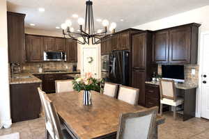 Kitchen featuring rich wood finish cabinetry, a center island, stainless steel appliances, and granite counter tops
