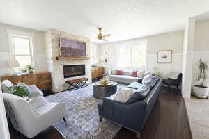 Living area featuring a wainscoted wall, a fireplace, and hardwood flooring