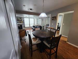 Dining space with french doors, dark wood finished floors, and a fireplace