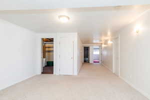 Spare room with light carpet and baseboards