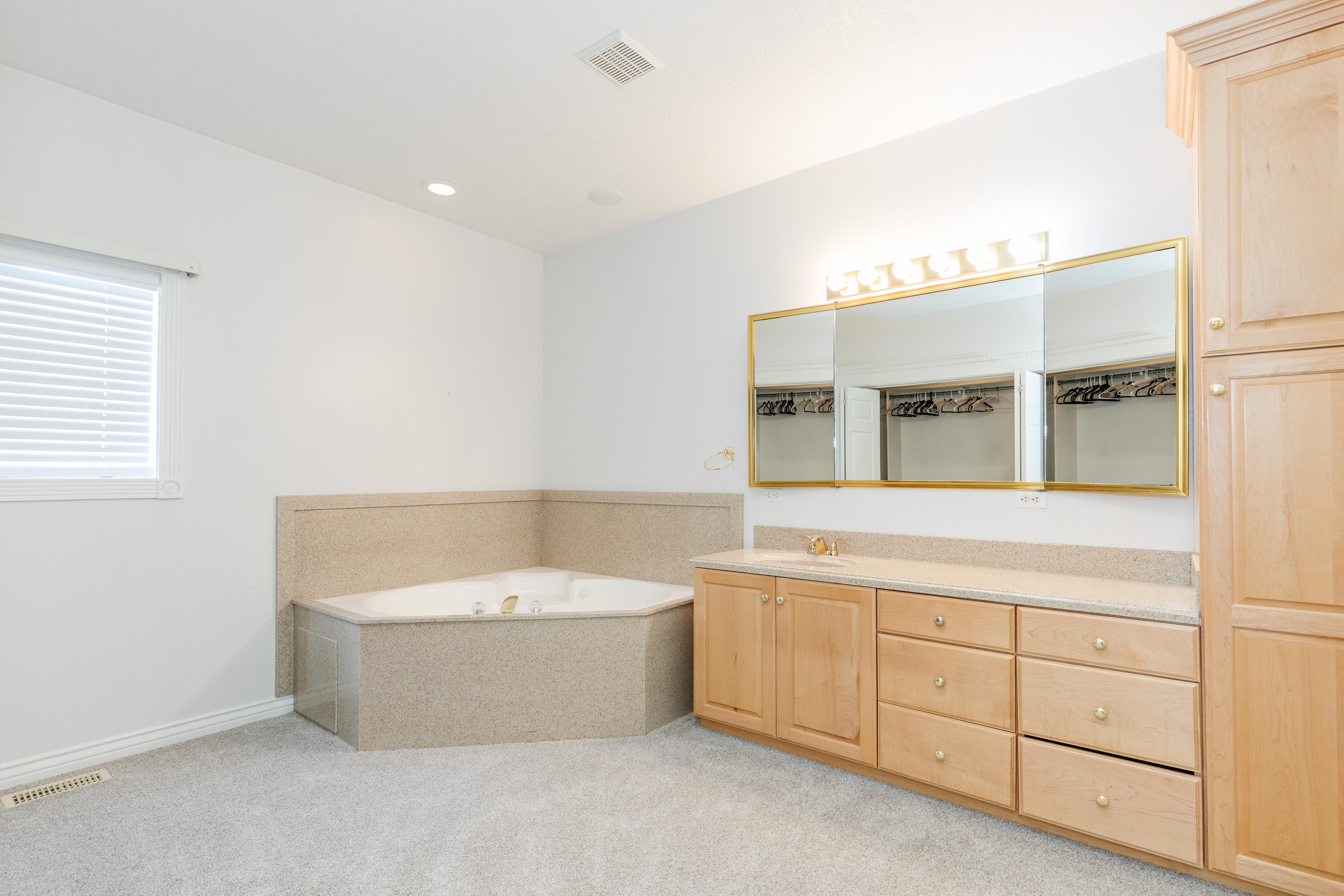 Full bathroom with vanity, light carpet, a bath, and recessed lighting