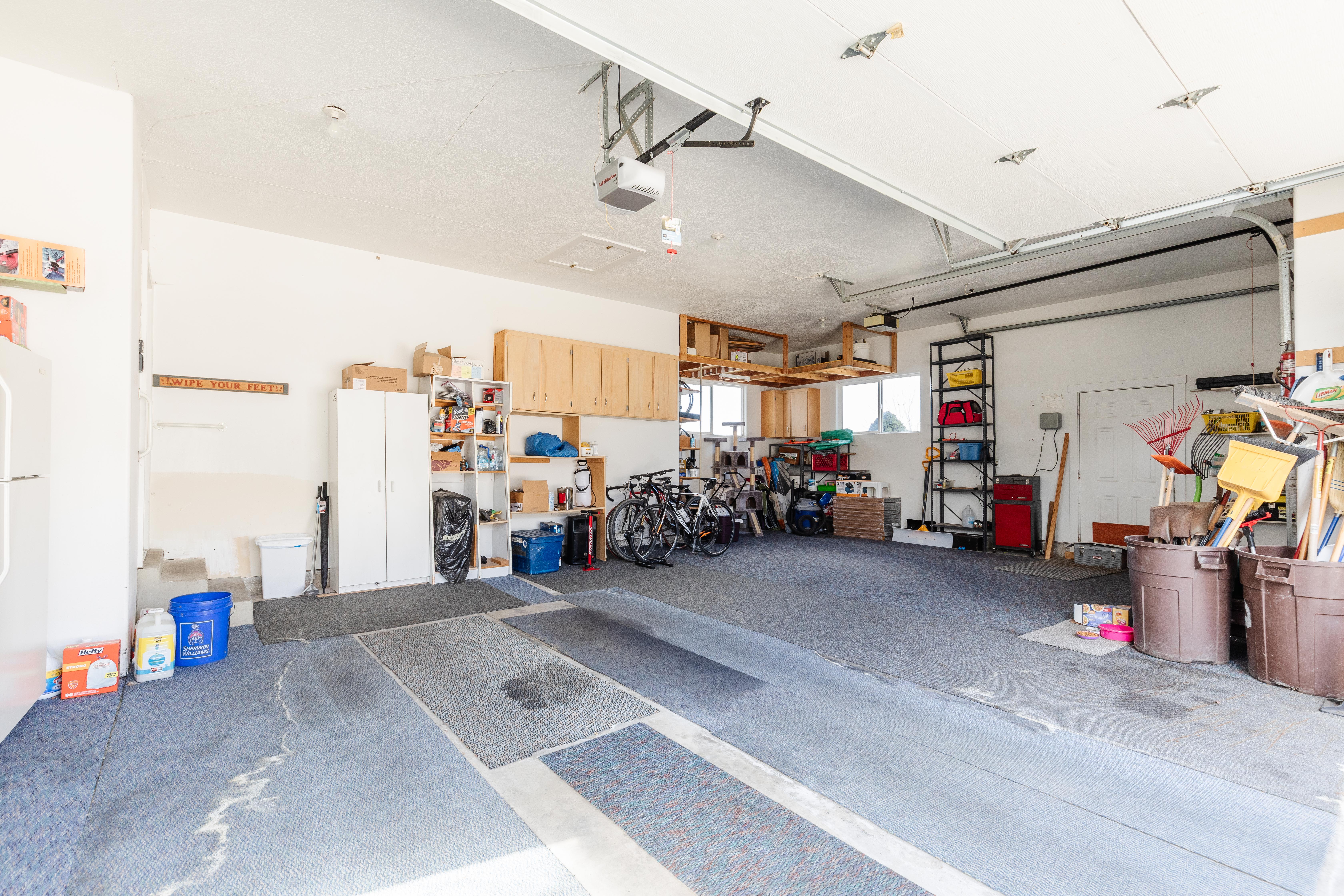 Garage with freestanding refrigerator and a garage door opener