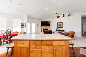 Kitchen featuring a breakfast bar, light countertops, open floor plan, a tile fireplace, and recessed lighting