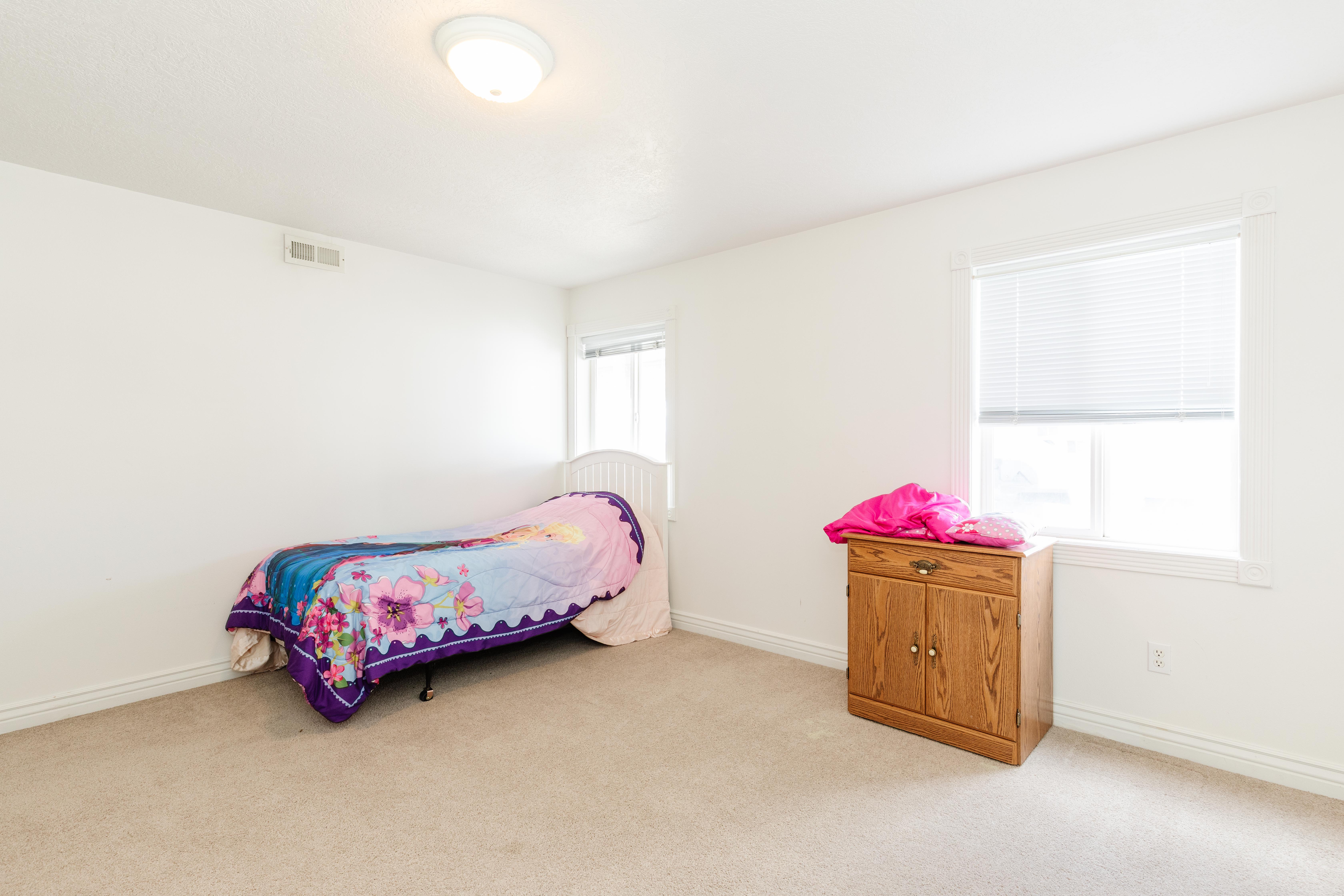 Bedroom with light carpet and baseboards