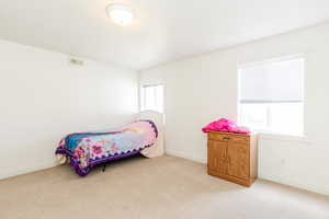 Bedroom with light carpet and baseboards