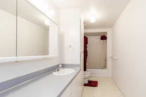 Full bath featuring light flooring, vanity, and shower / bathtub combination with curtain