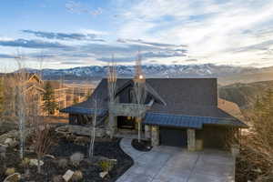 View of front of property with stone siding, a mountain view, covered porch, and a standing seam roof