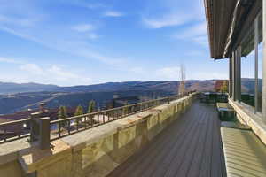 Wooden deck with a mountain view and a patio