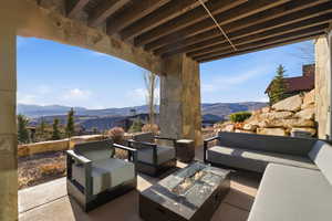 View of patio / terrace with an outdoor living space with a fire pit and a mountain view