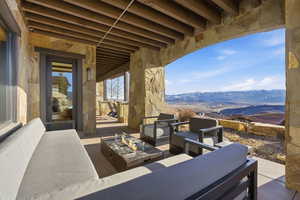 View of patio with a mountain view and an outdoor living space with a fire pit