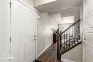 Entryway featuring baseboards and dark wood-type flooring