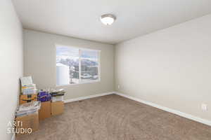Spare room featuring carpet flooring and baseboards