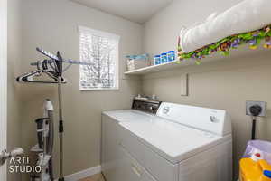 Laundry room with washer and clothes dryer and baseboards
