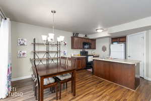 Dining space featuring hanging lights and dark wood-style flooring
