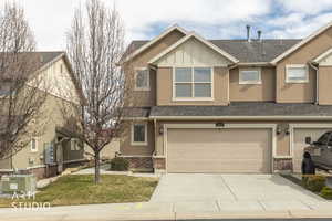 Craftsman-style home with brick siding, roof with shingles, board and batten siding, driveway, and stucco siding
