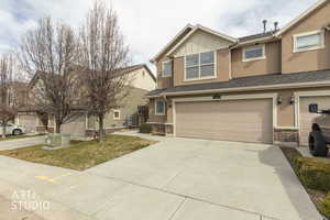 Craftsman house featuring brick siding, a garage, driveway, and stucco siding