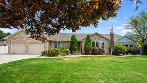 Single story home with a front lawn, driveway, an attached garage, brick siding, and a shingled roof