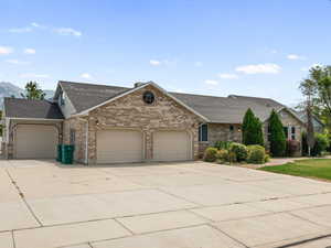 View of front facade featuring a garage, concrete driveway, brick siding, a shingled roof, and a mountain view
