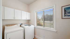 Laundry room with independent washer and dryer and cabinet space